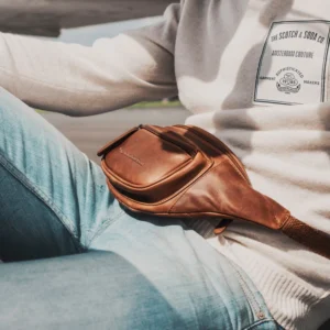 The Chesterfield Jack The Chesterfield Jack er hinn fullkomna og hagnýta mittis eða axlartaska fyrir dagsferð í miðbæinn þar sem hann hún er tilvalin stærð til að passa uppá öll verðmæti þín en samt þægileg. Taskan er úr ekta koníakslituðu leðri. Öll hólf eru með rennilásum sem auðvelt er að nálgast og hliðarvasi að aftan er þétt upp við líkama þinn sem þýðir að þú getur örugglega geymt mikilvægustu hlutina þína.