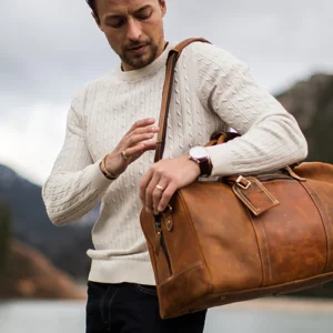 The Chesterfield William Leður Helgartaska. Ertur að fara í burtu um helgina? Þá er THE CHESTERFIELD leðurhelgartaskan okkar William fullkomin fyrir þig! Þessi rúmgóða helgartaska býður upp á nóg geymslupláss fyrir allt dótið þitt og er líka stílhrein og flott. Þessi glæsilega helgartaska er mjög hentug til að nota sem íþróttatösku,og í helgarfríið.Þessi helgartaska úr leðri hefur stórt aðalhólf (43 lítrar) með auka renndum vasa að innan. Aðalhólfið lokast með fallegum og sléttum rennilás. Þessi helgartaska kemur með langri og stillanlegri axlaról. Handföngin eru extra breið og því þægileg í hendinni. Þú getur auðveldlega viðhaldið þessari tösku með leðurvaxinu okkar, þetta er hreinsi- og viðhaldsvara í einu.